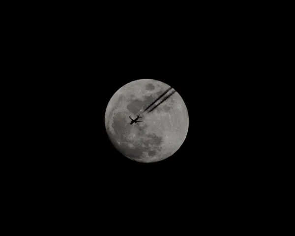 Plane silhouette against a full moon